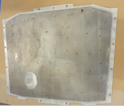 Base plate with a light-coloured surround and many small holes, with individual bolts fitted.