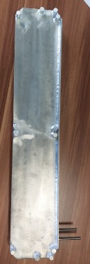 Narrow, bright metallic plate with bolted connections on both short sides, with two thin tubes beside it.